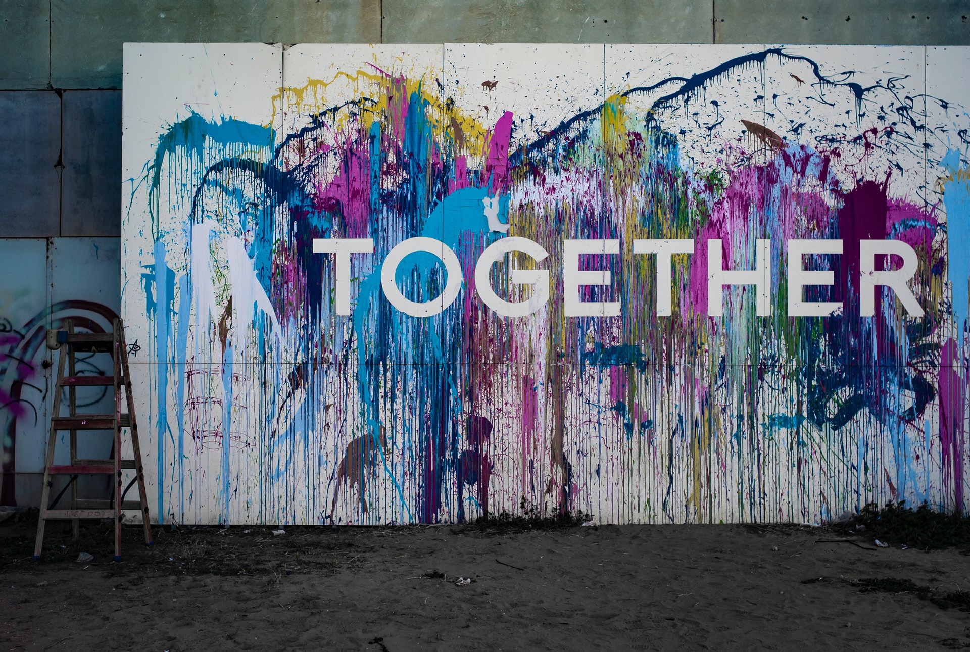 A wall splashed with paint and the word Together